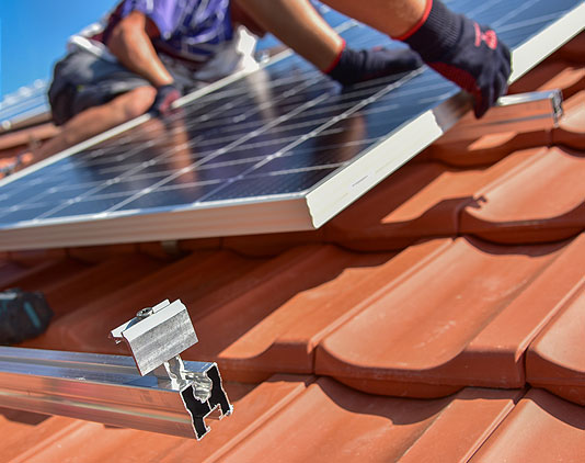 Dachdecker von Meisterdach Fladung bei der Installation von Photovoltaik-Modulen auf einem Steildach