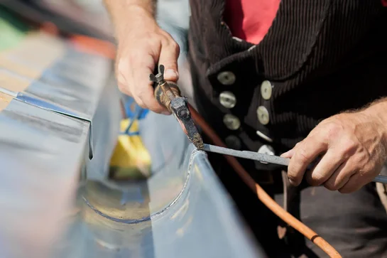 Dachdecker von Meisterdach Fladung bei Spenglerarbeiten an einer Dachrinne