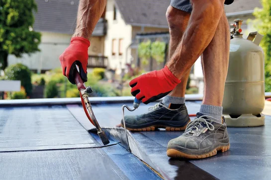 Dachdecker von Mesiterdach Fladung bei der fachgerechten Abdichtung eines Flachdachs
